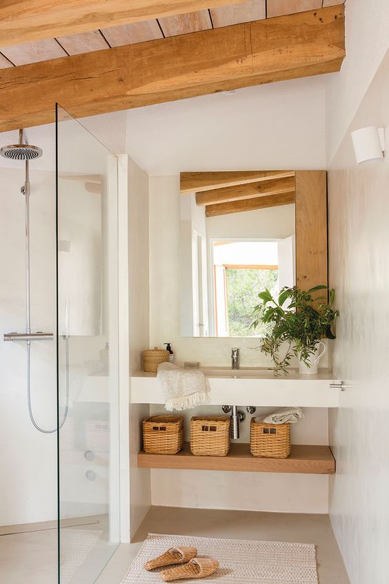 a neutral and welcoming bathroom with a wooden roof and beams, a built in vanity and a shelf, a shower space and a mirror