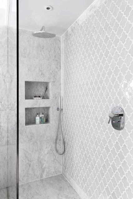 a neutral contemporary shower space with grey stone and arabesque tiles, with niches for storage is a lovely space to take a shower
