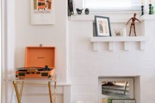 a non-working white brick fireplace used to display vinyl and posters is a lovely idea and it looks very chic and pretty