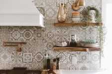 a pretty white kitchen with shaker cabinets, a grey and white Moroccan tile backsplash and stained open shelves