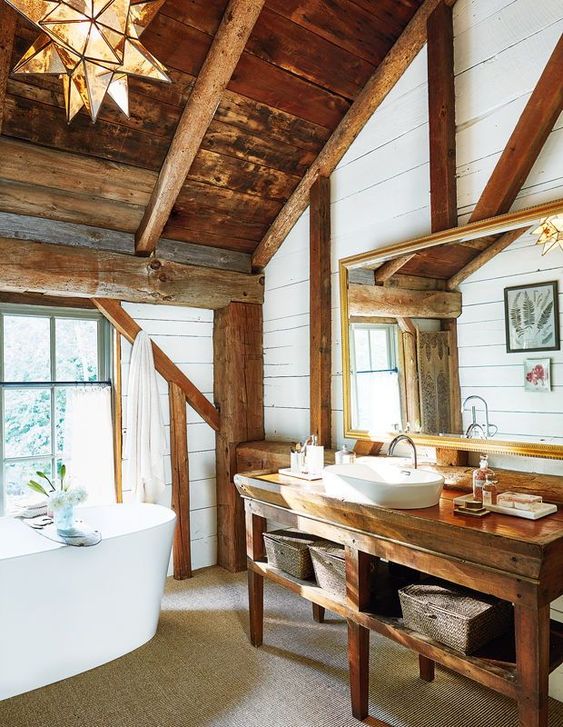a rustic bathroom with a wooden roof and beams, a wooden vanity, an oval tub and a catchy star shaped lamp
