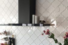 a shiny and polished black kitchen with white arabesque tile backsplash is a very elegant and chic idea to make a statement