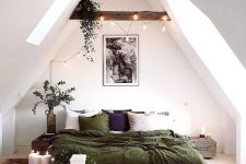 a small attic bedroom with dark-stained beams and lights on them, a bed with green bedding, reclaimed wood nightstands and potted plants