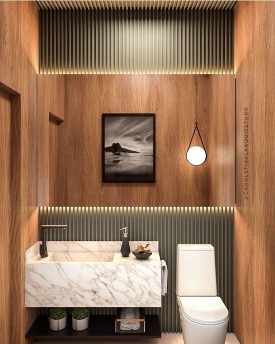 a small powder room clad with plywood and green panels, with a floating stone sink, a cool pendant lamp and an open shelf for storage