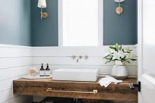 a small powder room with blue and white planked walls, a reclaimed wooden vanity, a square vessel sink and sconces is chic