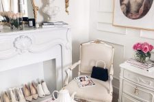a sophisticated closet space with paneled walls, a chic dresser, neutral refined furniture, a vintage fireplace used for displaying shoes on magazines