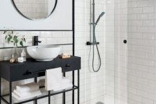 a stylish bathroom clad with subway and hex tiles, a console sink, a round mirror, black fixtures looks laconic and chic