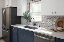 a two-tone kitchen with white and navy cabinets, chic Moroccan tiles on the backsplash, a rug that echoes with them