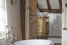 a vintage bathroom with wooden beams and floors, a separate space with a vintage vanity and a clawfoot bathtub