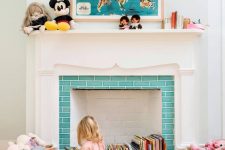 a vintage fireplace with a lovely white mantel, with turquoise tiles and colorful books stored inside it is a centerpiece of the room