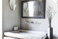 a wabi-sabi bathroom with concrete walls and a wooden floor, a shabby chic reclaimed wood vanity and a stone vessel sink plus a mirror in a shabby chic frame