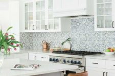 a white farmhouse kitchen with white stone countertops, a blue Moroccan tile backsplash and leather stools is amazing