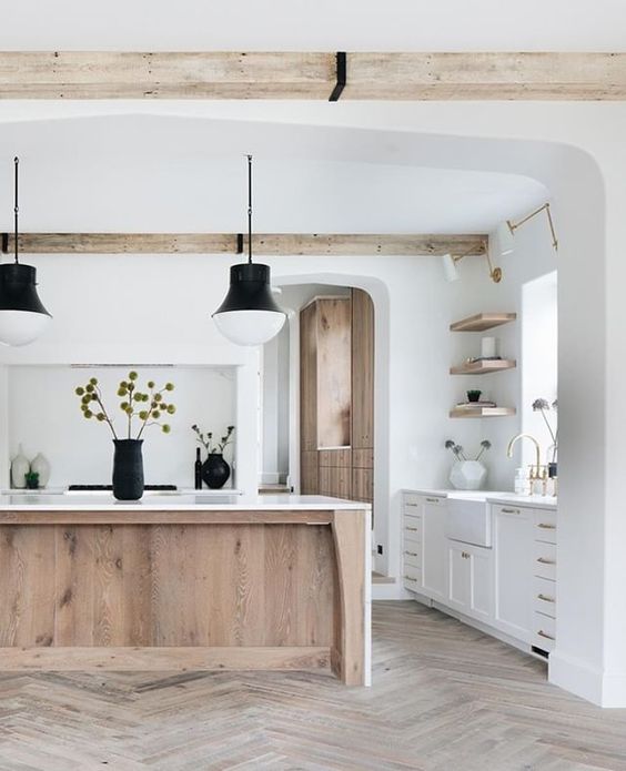 an airy kitchen with white cabinets, a stained kitchen island, wooden beams and open shelves that echo with this island is wow