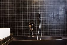 a cool black bathroom design with an all-black bathtub