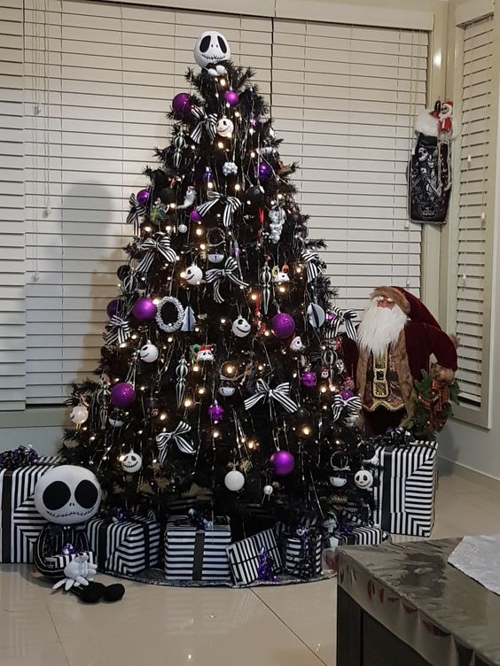 a black Halloween tree with black, white and purple ornaments, with striped bows and lights is very stylish