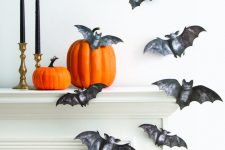 04 beautiful painted black paper bats attached to the wall and mantel, orange pumpkins and black candles in gold candlesticks