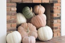 06 a modern fireplace with neutral and pastel pumpkins is a cool idea for a modern fall-embracing space and is an easy to realize decor idea