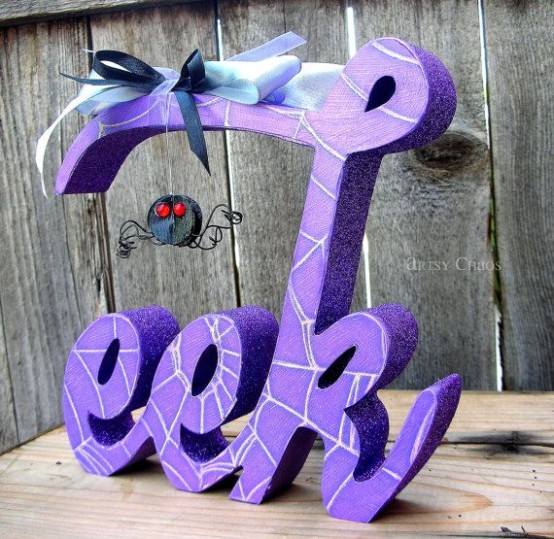 a bold purple glitter Halloween decoration with a little fun spider and a blue bow on top is ideal for Halloween