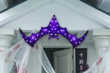 11 a bold and pretty purple bat marquee light over the entrace instead of a wreath or another Halloween door decoration