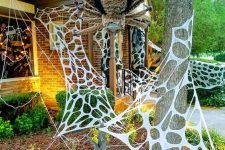 11 faux spiderweb and an oversized and scary spider are amazing to style your outdoors or front porch for Halloween and are cool