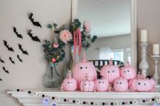12 a pretty pastel Halloween mantel with bead and ghost and bat garlands, pink pumpkins with googly eyes and black bats on the wall