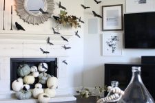 14 black paper bats covering the fireplace and the wall, natural pumpkins in the fireplace, black candles and blackbirds for Halloween