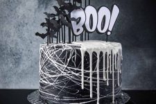 21 a black Halloween cake with white drip and lots of black paper bats and white letters is a gorgeous idea to go for