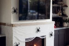 24 a fireplace covered with faux spiderweb and black spiders, a couple of heirloom pumpkins is a gorgeous idea for Halloween