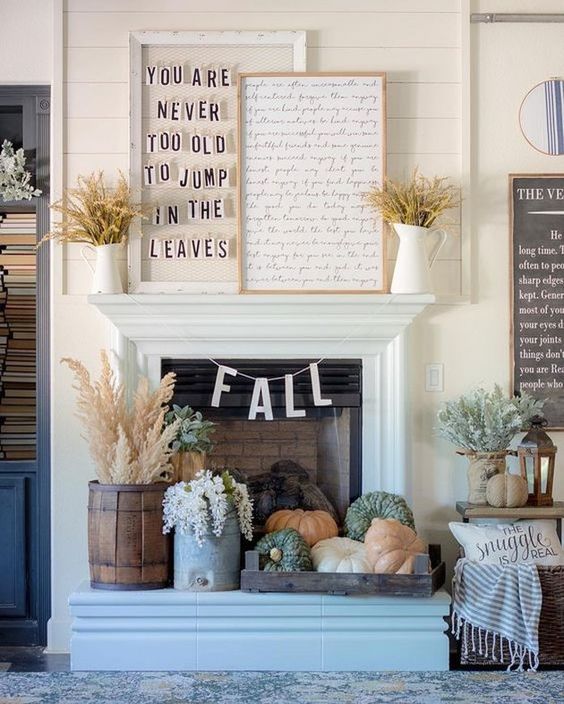 fall fireplace styling with a tray with heirloom pumpkins, blooms and wheat in a wooden bucket plus wheat in jugs on the mantel