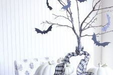 24 simple farmhouse Halloween decor with a basket with white pumpkins, branches with black bats attached to them