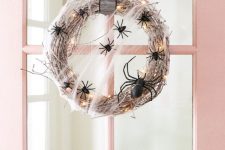 25 a lit up Halloween wreath with black spiders and a striped ribbon is a chic and cool idea for styling your front door and not only