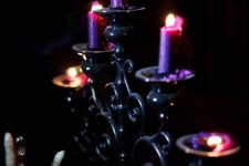 25 a refined black candelabra with purple candles is a beautiful decoration for Halloween and it looks cool and chic