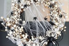 28 a stylish and scary Halloween wreath with lots of black spiders and a large one, realistic spiderweb and other stuff just wows