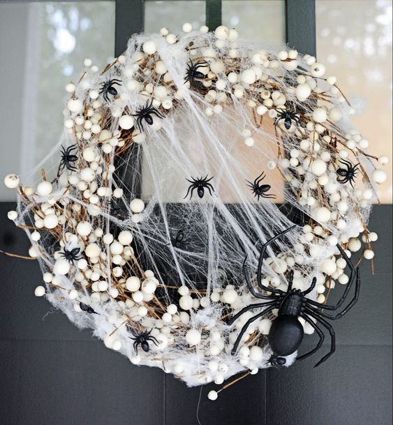 a stylish and scary Halloween wreath with lots of black spiders and a large one, realistic spiderweb and other stuff just wows