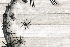 30 an elegant Halloween wreath of a hoop, with spiderwebs, black spiders and a striped bow on top is a chic solution