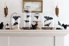 34 a Halloween mantel decorated with black paper bats in cloches and with blackbirds is a cool idea to go for