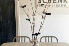 36 a Halloween centerpiece of white pumpkins, branches with black paper bats attached to them is a cool solution that looks nice