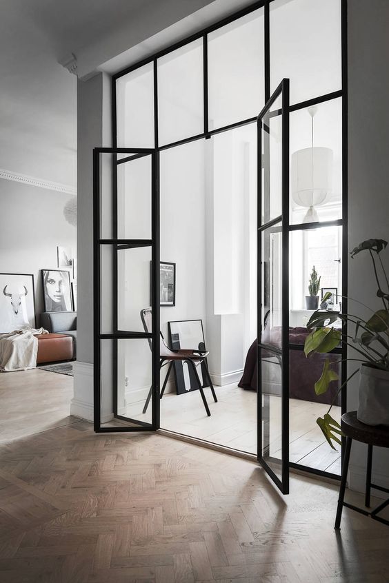 Scandinavian interiors with black framed French doors to fill the spaces with light and connect them with each other