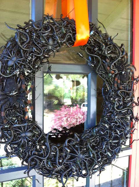 a black vine Halloween wreath covered with snakes, spiders and insects of all kinds is a lovely idea to style your front door