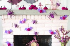 a bold Halloween mantel with hot pink velvet pumpkins, purple and pink bats and spiders and pink glitter skeleton hands