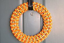 a candy corn Hallowee wreath with a black ribbon bow is a fresh and pretty idea for any styling and decorating