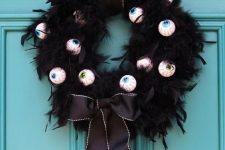 a cool and easy to DIY Halloween wreath of black feathers, scary eyes and elegant black ribbon is gorgeous and amazing