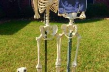 a creative Halloween display with two skeletons and three skeleton dogs possibly portraying the owners of the house