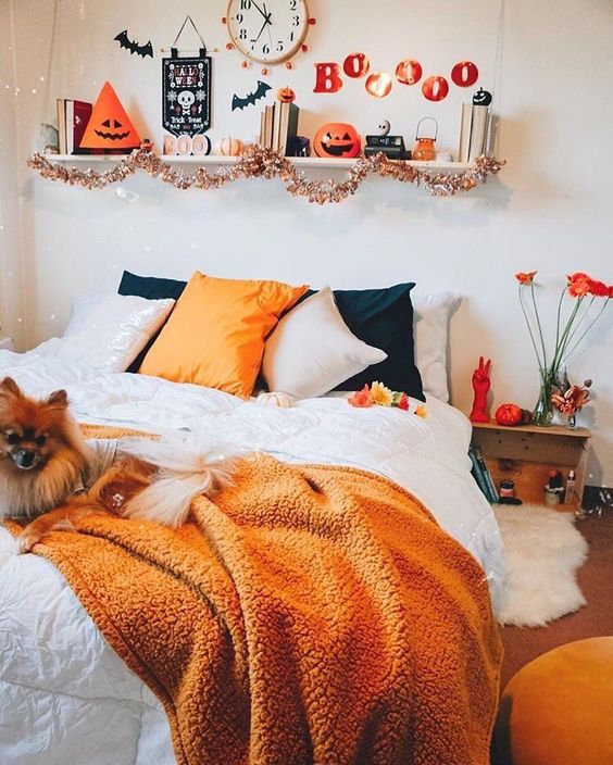 a fall to Halloween bedroom with orange and black bedding, orange blooms, faux pumpkins, bats, letters and some Halloween decor