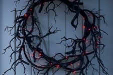 a faux black branch Halloween wreath with lights is a very bold, stylish and spooky decor piece for Halloween