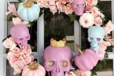 a glam candy-colored Halloween wreath of skulls, faux blooms and feathers is a very cute and lovely idea to go for