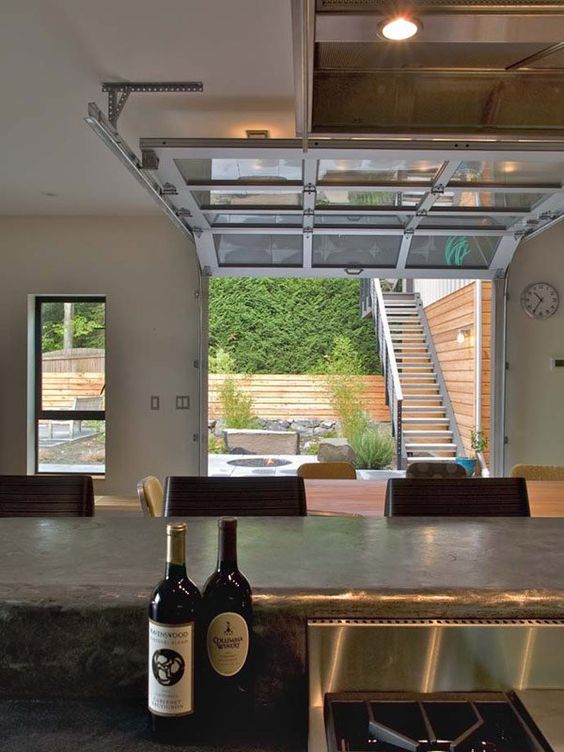 a glass-paneled garage door virtually eliminates the division between the main room and an outdoor living area