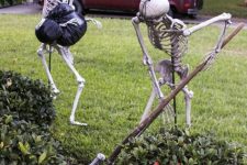 a hilarious Halloween scene of skeletons burying a body is a gorgeous solution for your outdoor Halloween decor