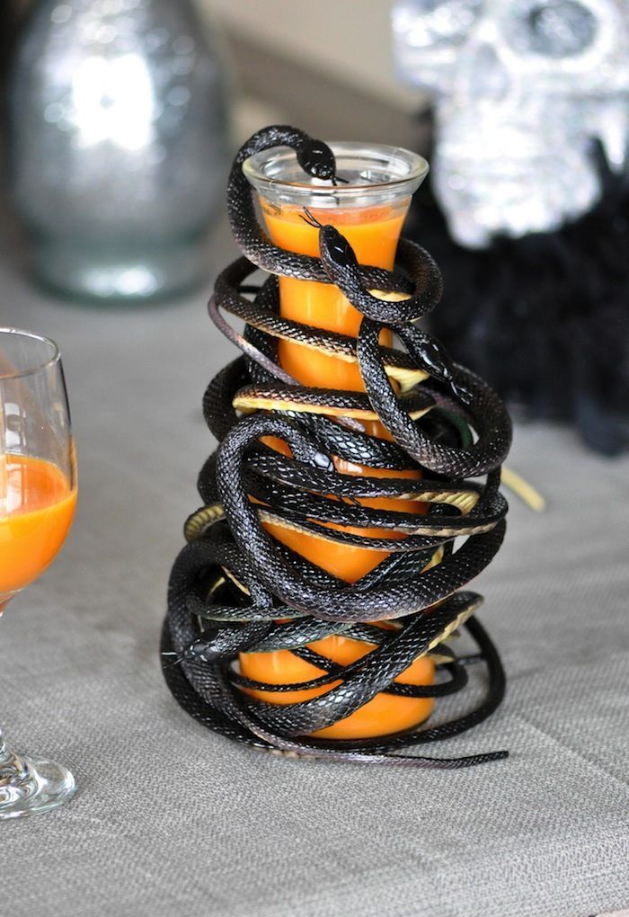 a jug with juice completely wrapped with black snakes is a stylish and scary solution for Halloween