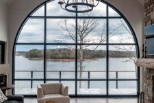 a living room with an oversized arched window that brings a gorgeous view inside